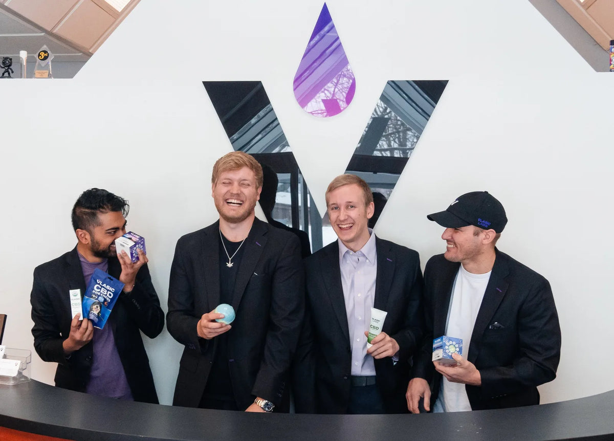 The Vlasic Labs team laughing in front of the Vlasic logo, holding products